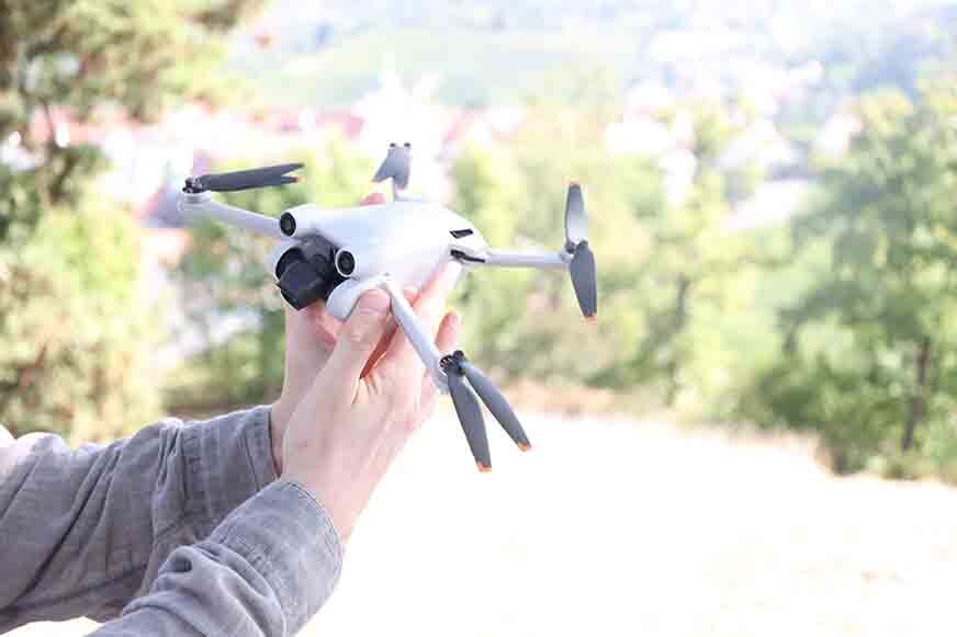 Die DJI Mini 3 Pro wird in der Hand gehalten.